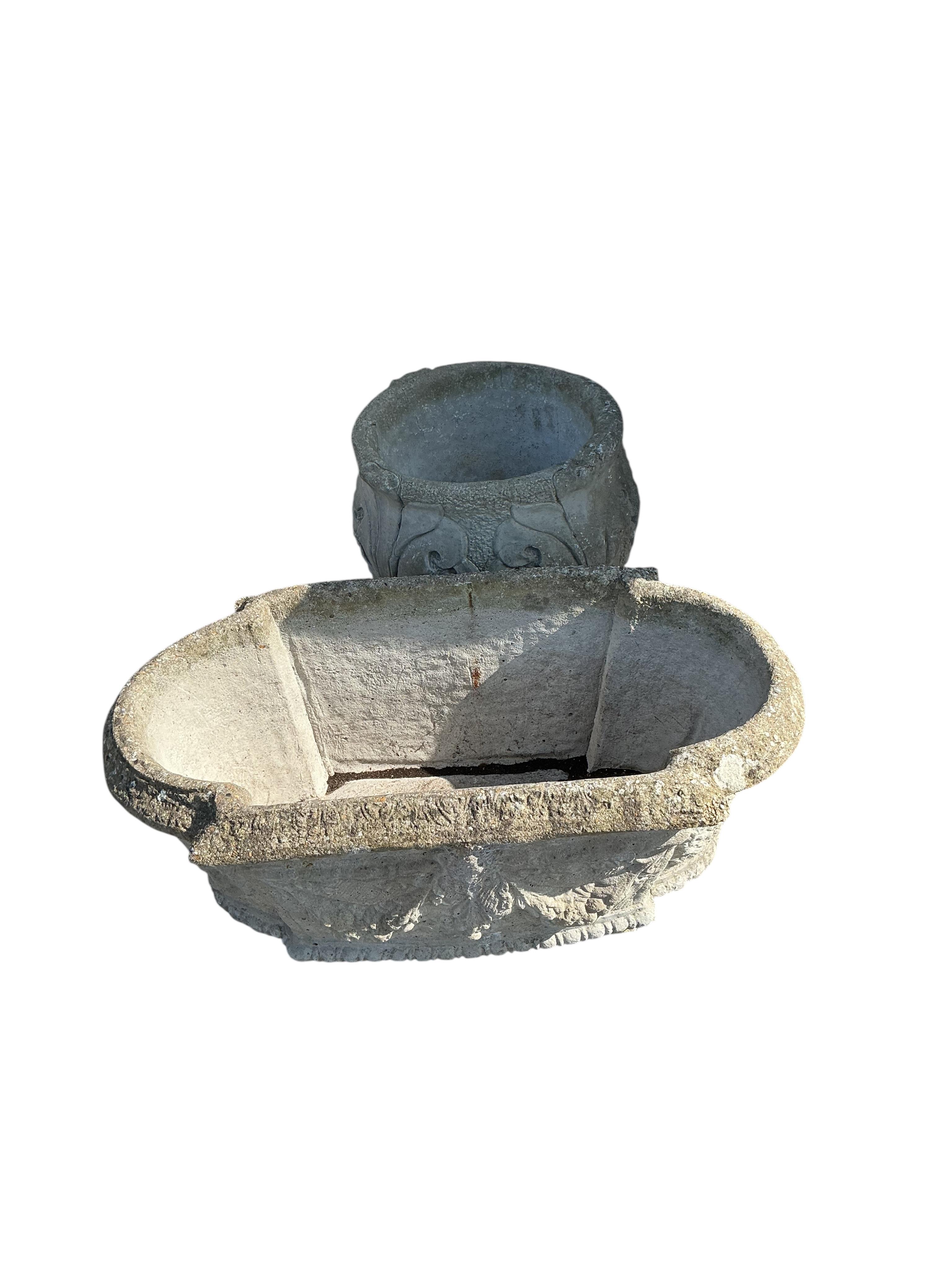 An oval reconstituted stone garden planter, width 80cm, height 30cm together with a circular stone planter